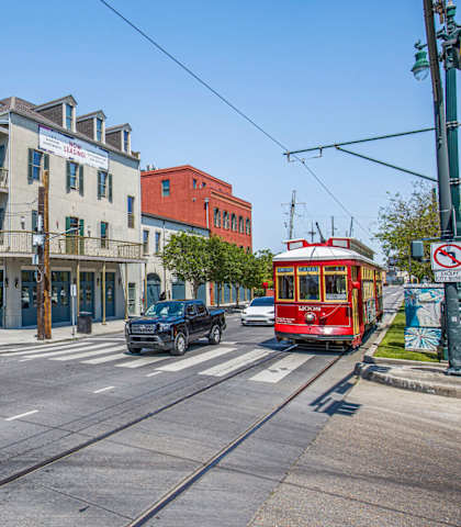A street view with a red tram on the right and a building with a sign that says "The".