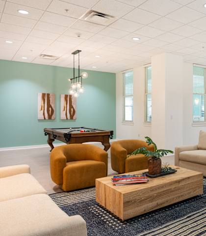 A living room with a sofa, armchairs, and a coffee table.