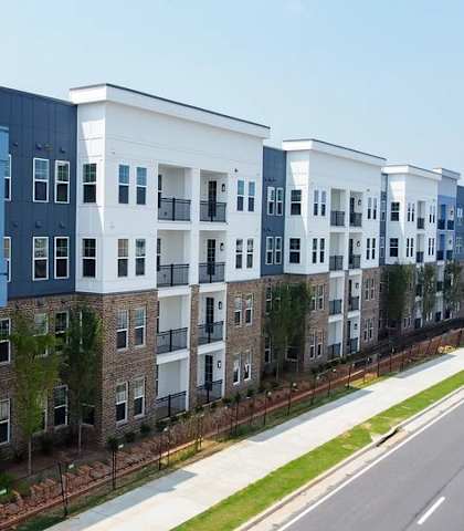 A row of modern apartment buildings with balconies and windows.