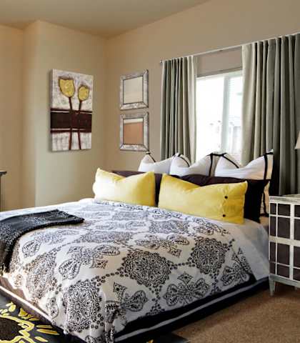 A bedroom with a large bed and a desk with a chair.
