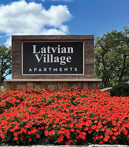the sign apartments in front of red flowers
