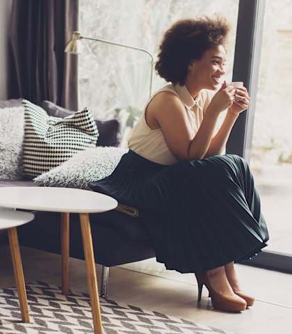 stock image- woman drinking coffee in living room