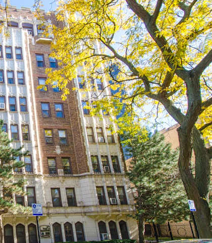 a large brick building with trees in front of it