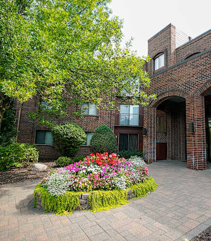 the exterior of a brick building with a flower garden
