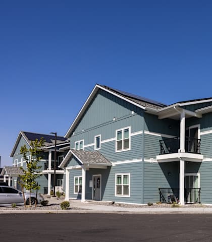 a large blue house with a street in front of it
