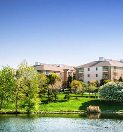 a park with a lake in front of a building