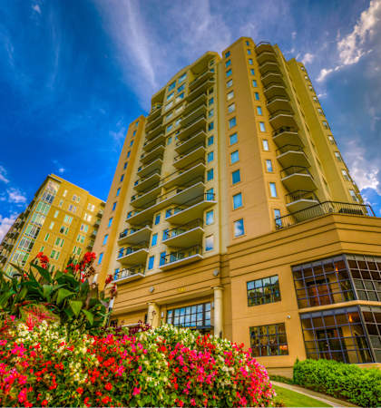 a tall building with flowers in front of it
