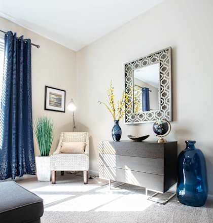 a living room with a dresser and a mirror