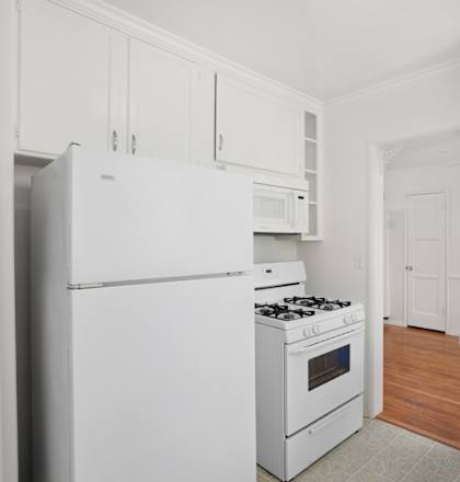 a white kitchen with white appliances and white cabinets