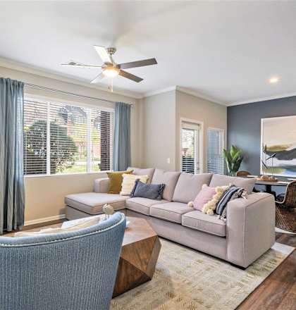 A living room with a couch, chair, and a ceiling fan.