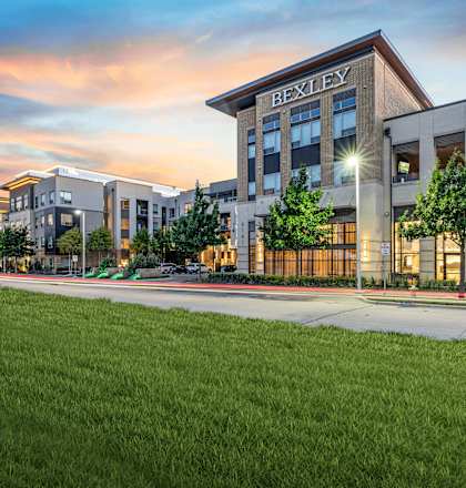 an exterior view of a building with green grass and a sidewalk