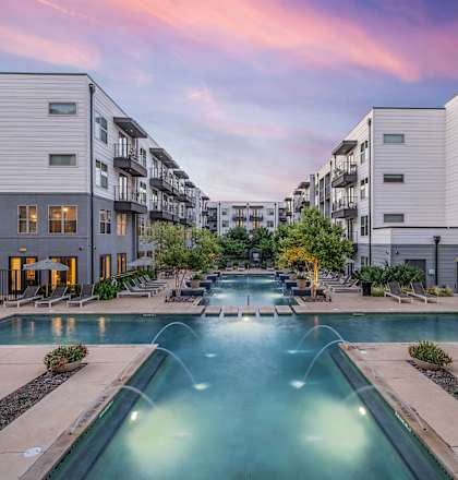 an apartment building with a swimming pool and buildings