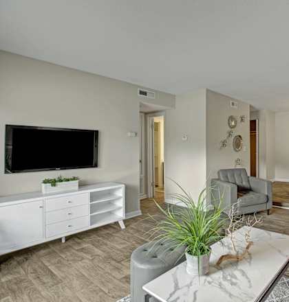 a living room and dining room with a table and a television