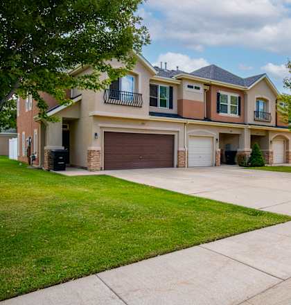 A two-story house with a garage and a driveway.