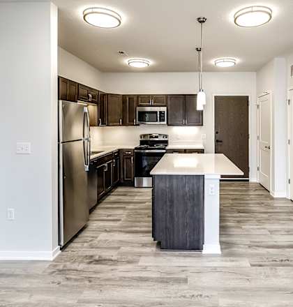 a kitchen with a large island and stainless steel appliances