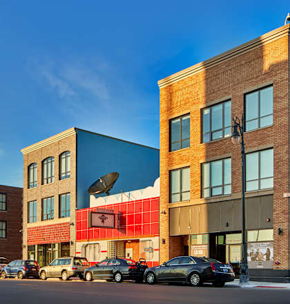 a row of buildings on a city street with a blue sky in the background