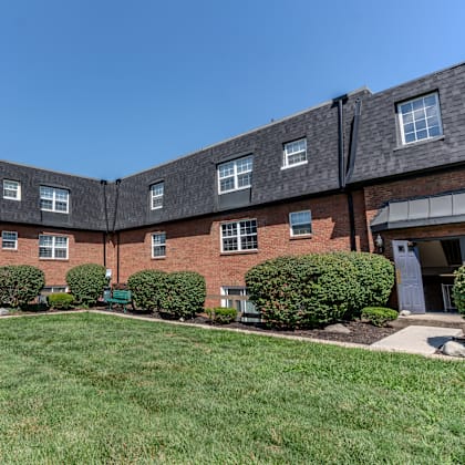 a large brick building with a yard in front of it