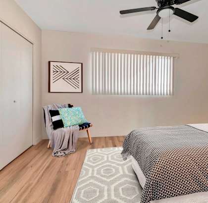 a bedroom with a large bed and a ceiling fan