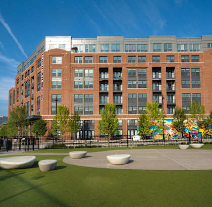a large brick building with a courtyard in front of it