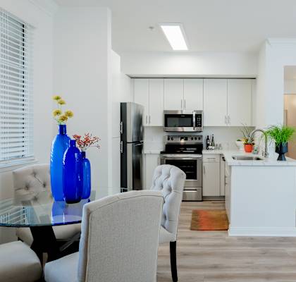 A modern kitchen with a dining table and chairs.