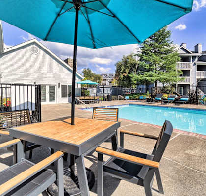 our apartments have a pool and table with a blue umbrella