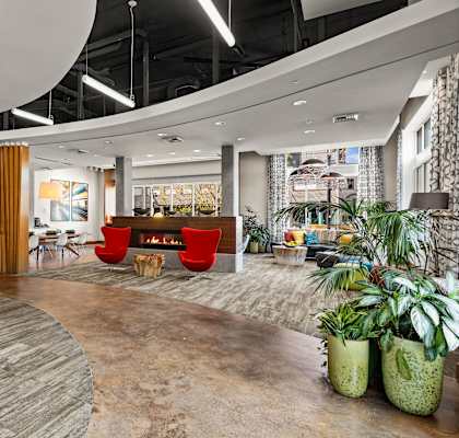 the lobby of an office with a fireplace and plants