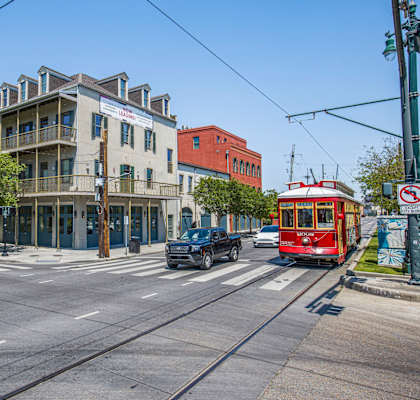 A street view with a red tram on the right and a building with a sign that says "The".