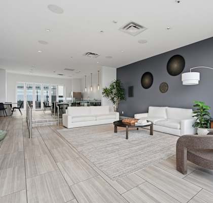 A modern living room with white furniture and a wooden floor.