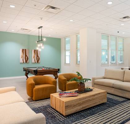 A living room with a sofa, armchairs, and a coffee table.
