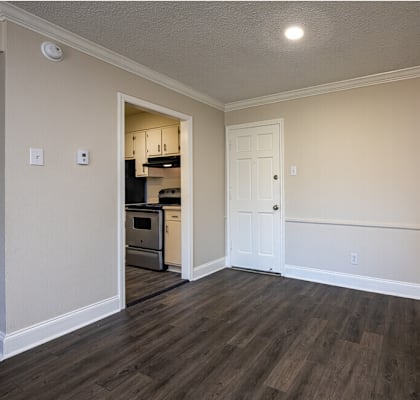A kitchen area with a white door and a small fridge.