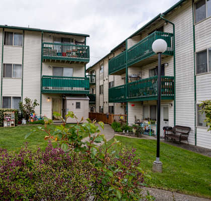 a picture of two apartment buildings with green and white railings
