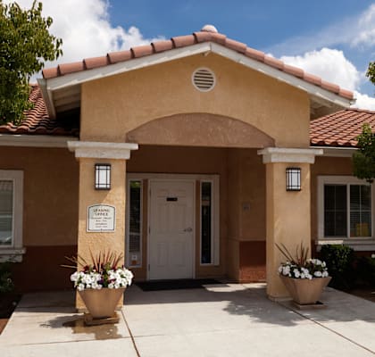 a brown building with a white door and a red tile roof