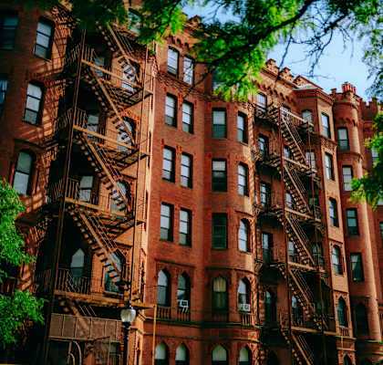 A red brick building with a fire escape on the side.