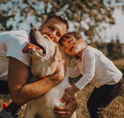 young couple playing with their dog in the park