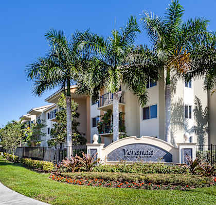 a large apartment building with palm trees in front of it