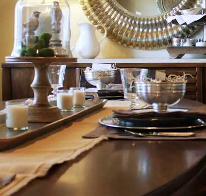 a dining room with a wooden table and a mirror