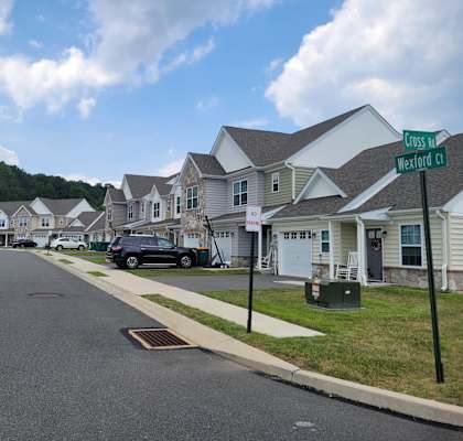 a row of houses in a neighborhood with a street sign in the foreground