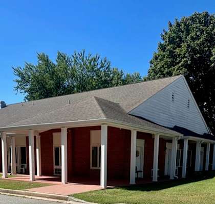 a red brick building with white pillars and a gray roof
