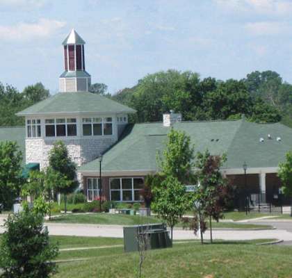 A church with a steeple and a green roof. at The Legends at Steeplechase Apartments, Richwood