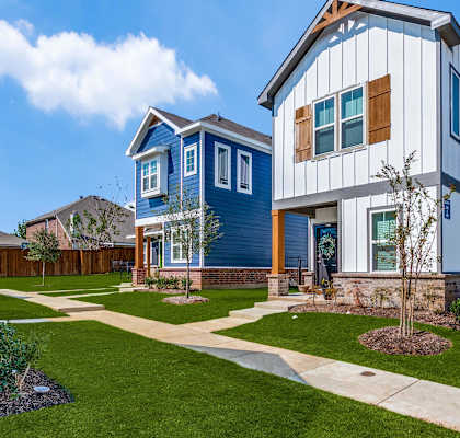 a blue and white house with a sidewalk in front of it