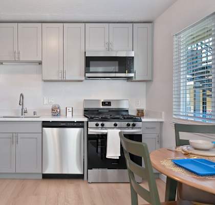 A kitchen with a stainless steel refrigerator, oven, and microwave.