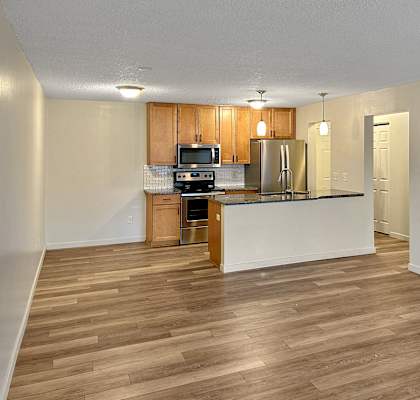 A kitchen with wooden floors and white walls.