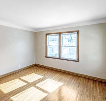 A room with a wooden floor and a window.