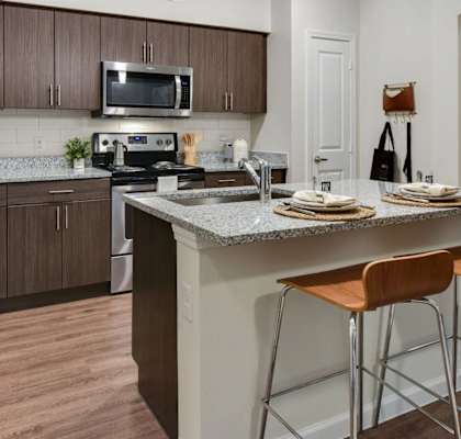 a kitchen with a counter top with bar stools