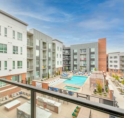 a balcony with a view of an apartment building and a pool