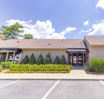 a white building with a glass door and a black awning