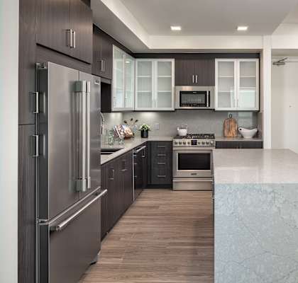 a kitchen with stainless steel appliances and white counter tops