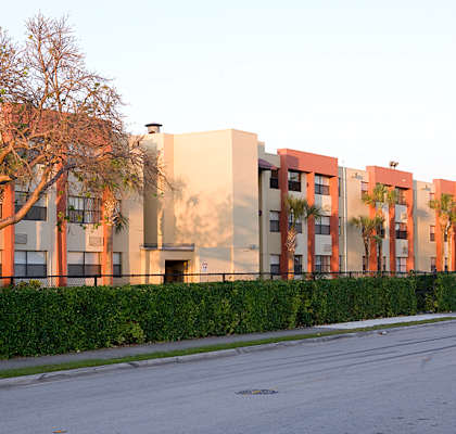 a row of apartment buildings with trees in front of them