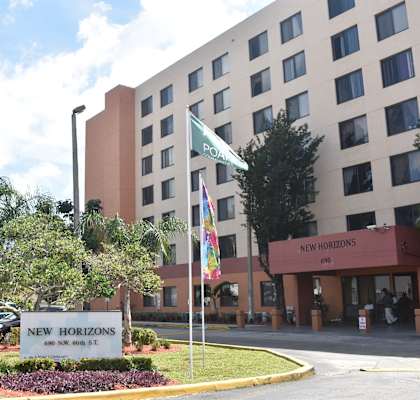 a building with a sign that says new horizons in front of it