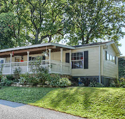 a home with a lawn and trees in the background